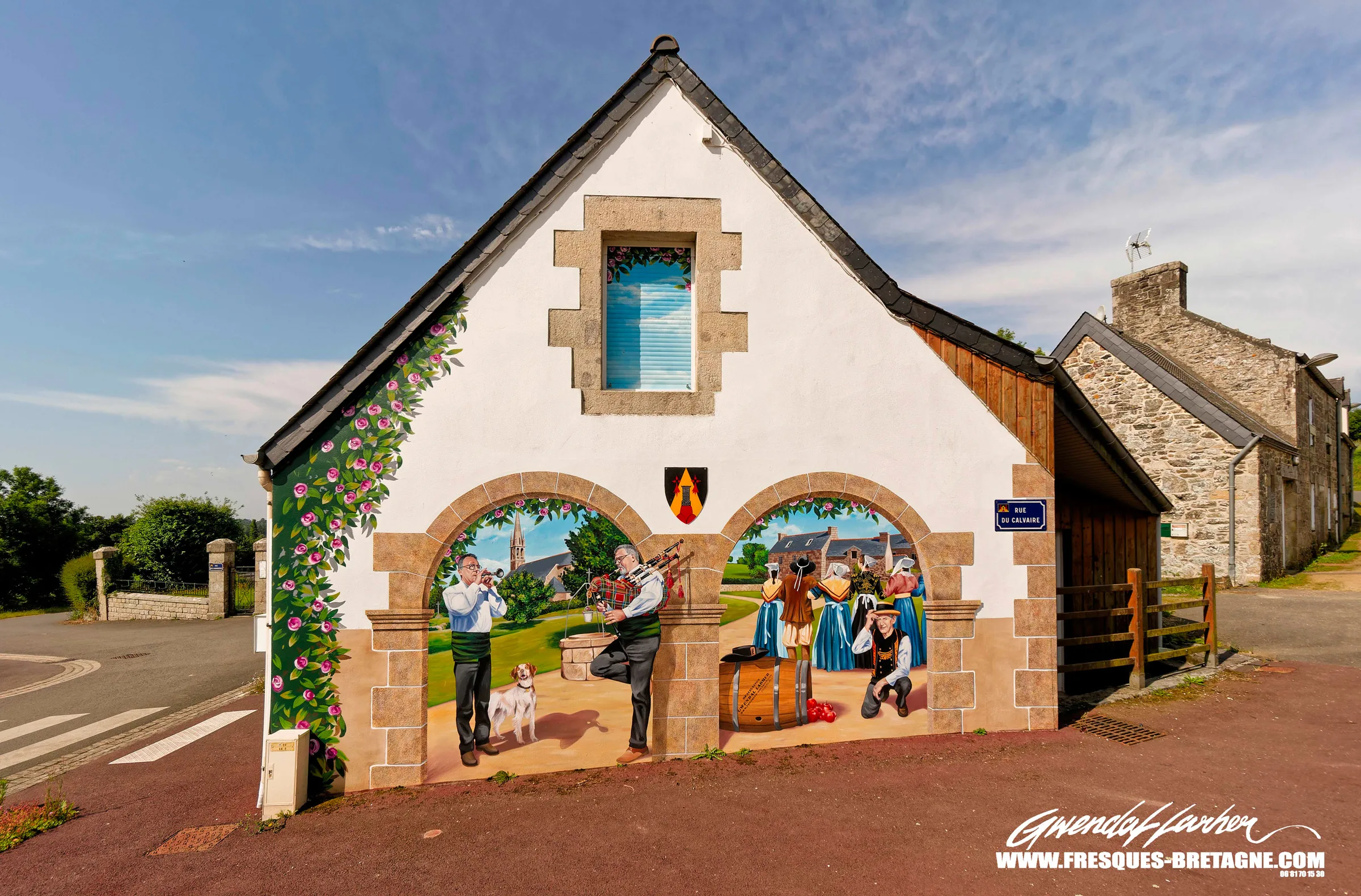 Fresque de pignon en trompe-l'œil, deux arches en granit ouvrant sur des scènes de fête bretonne avec sonneurs et danseurs en costume traditionnel, centre-bourg de Calanhel